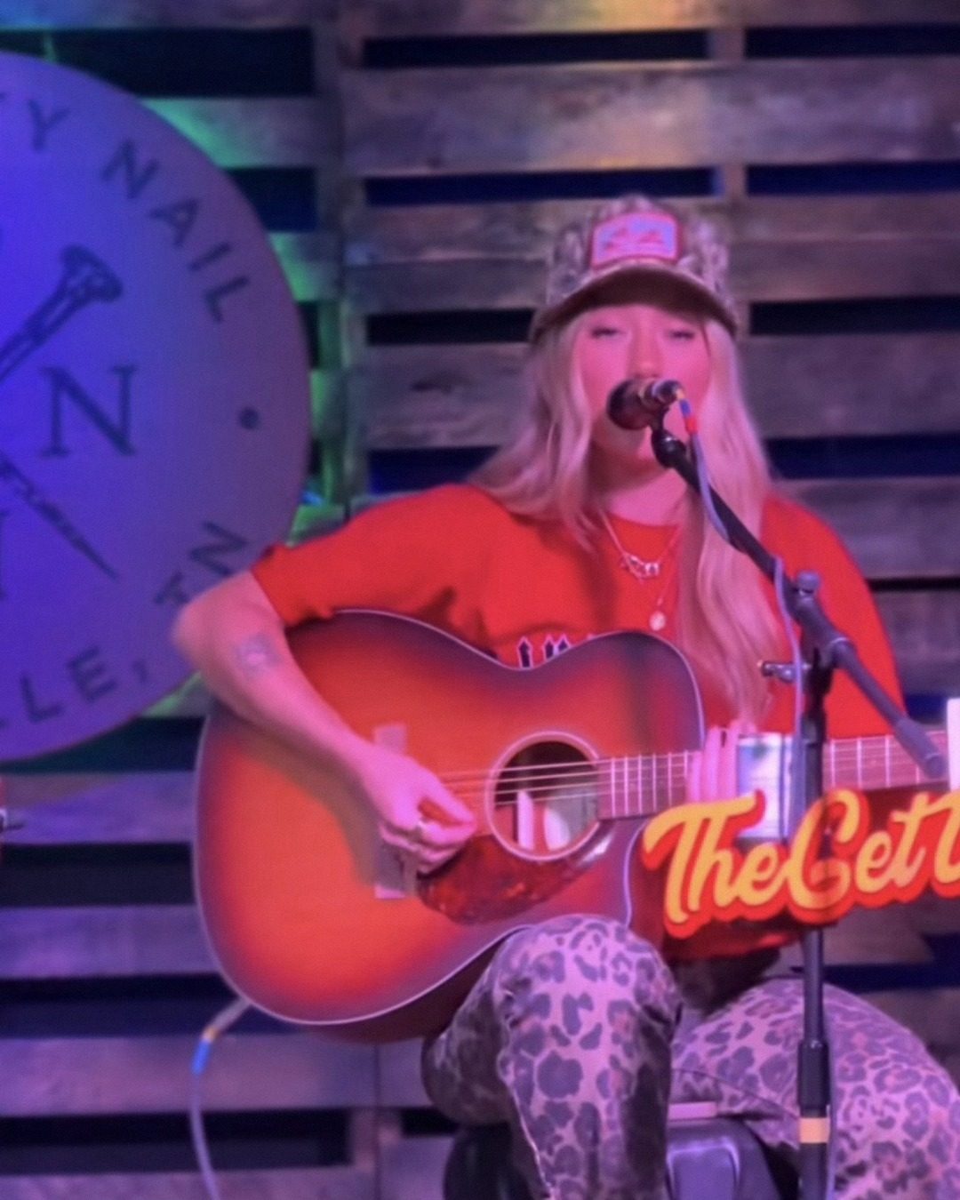 Chloe Wilson performing live with an acoustic guitar